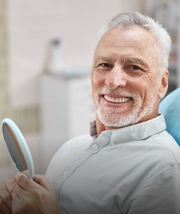 man smiling sitting in a dental office